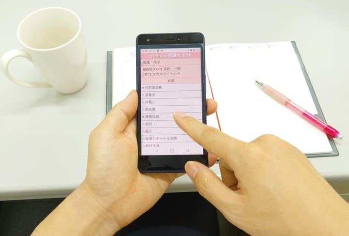 athome看護Mobileスマホ操作中