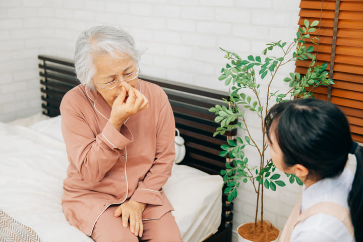 鼻が詰まって苦しそうな利用者さんのイメージ写真