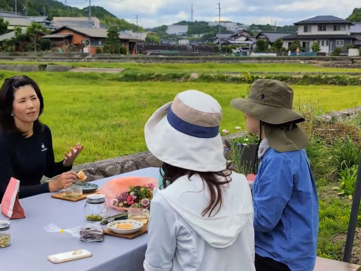 外で植物についての話をしている写真