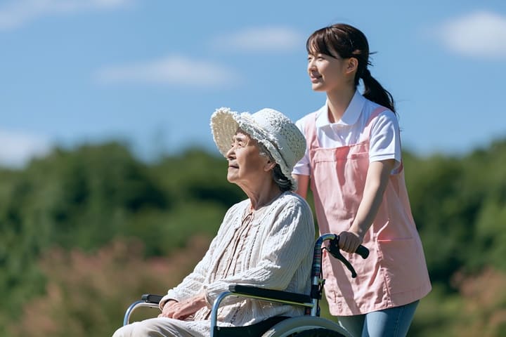 車椅子を押す介護スタッフイメージ画像